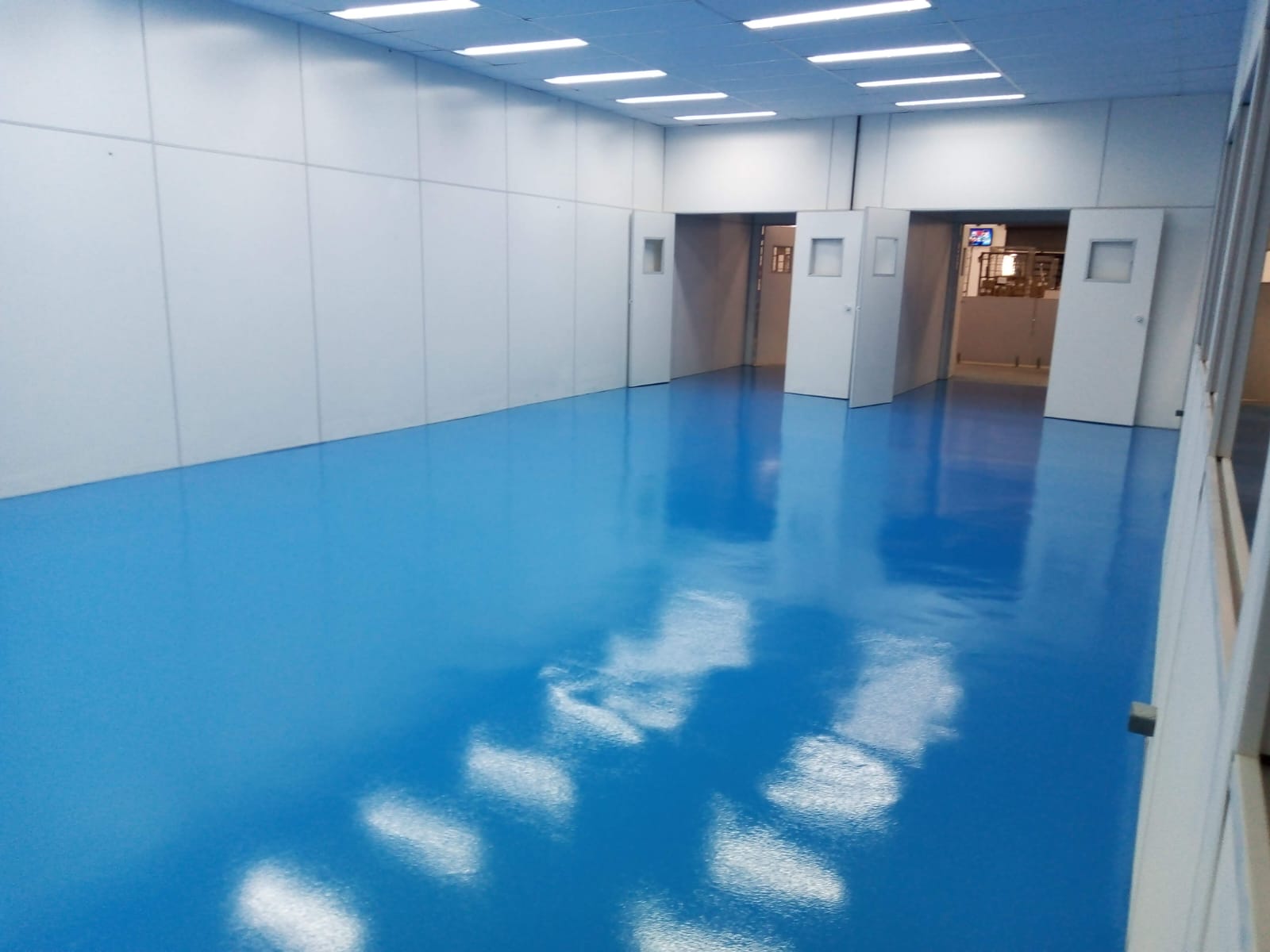 Piso epóxi azul em sala de produção farmacêutica