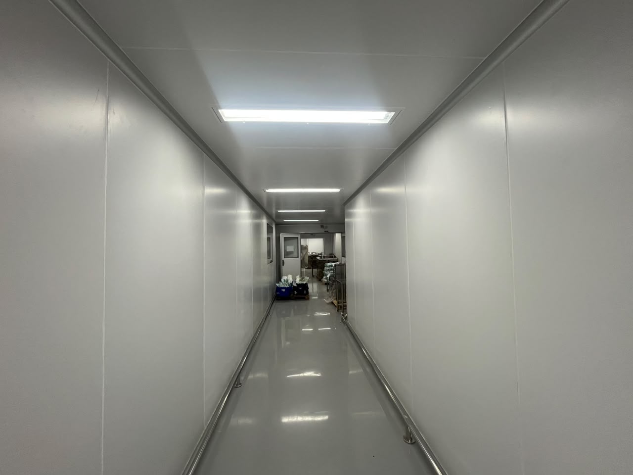 Corredor de sala limpa com painéis isotérmicos e piso epóxi instalado pela IsoClean Brasil